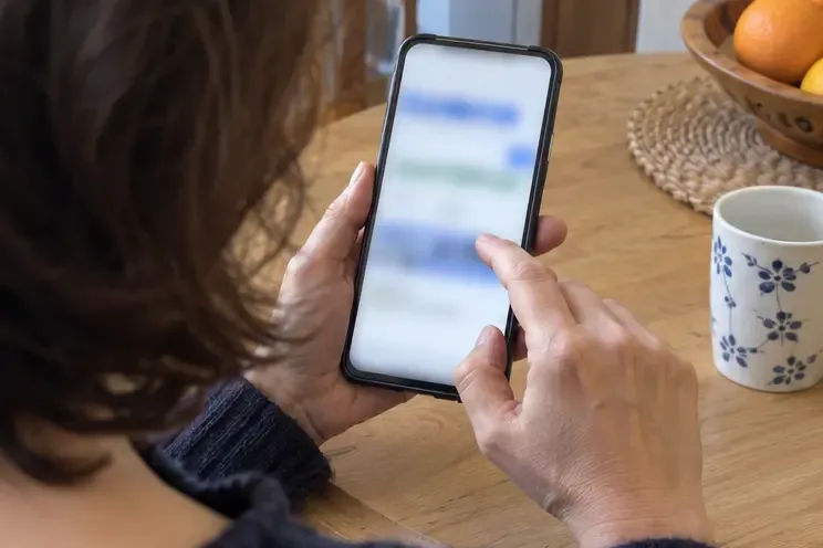 Una persona consulta en un teléfono una página de información ambiental con la pantalla desenfocada