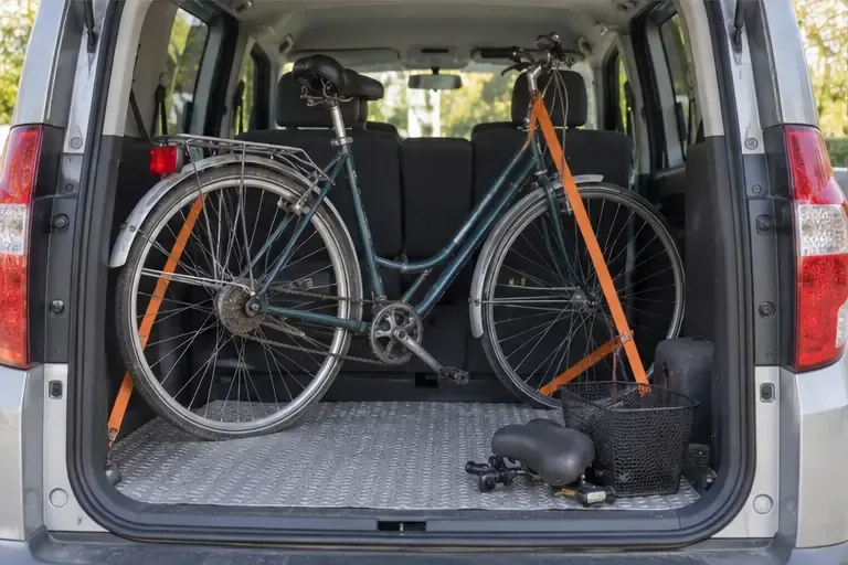 Bicicleta antigua sujeta en posición vertical dentro de un vehículo para transportarla