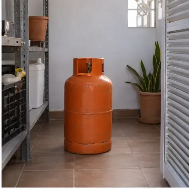 Una bombona de gas permanece vertical sobre un suelo estable en una zona ventilada