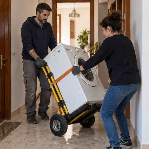 Dos personas sujetan una lavadora con una carretilla y una cincha en el pasillo de una vivienda