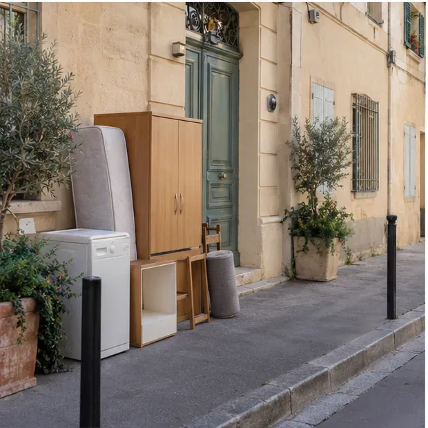 Une armoire, un matelas et un appareil ménager sont regroupés devant une façade provençale