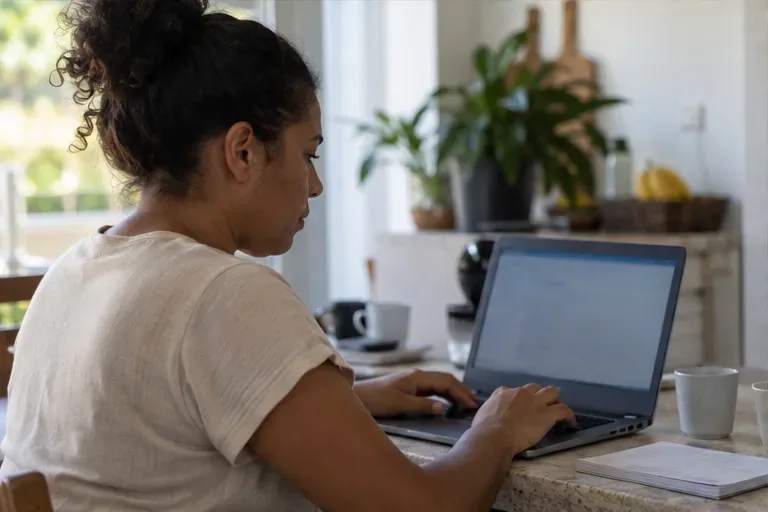 Usuária consulta informações financeiras pelo computador, alternativa útil quando a leitura do extrato é mais confortável em uma tela maior.