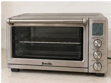 A clean stainless-steel Breville countertop toaster oven reassembled with a dry wire rack inside.