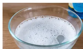 A bowl of cleaning water prepared beside a dry-erase eraser