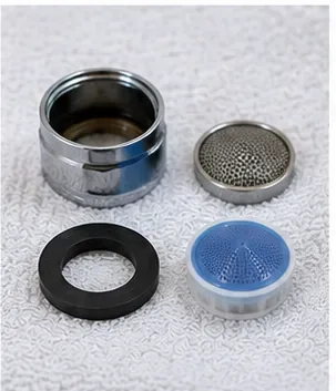Clean faucet aerator components resting separately on a white towel after rinsing.