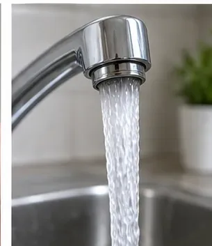 A steady even stream of water flows from the reinstalled chrome faucet aerator into a sink.