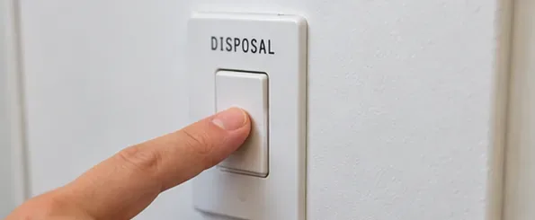 A finger switching off the wall switch labeled disposal before cleaning begins.