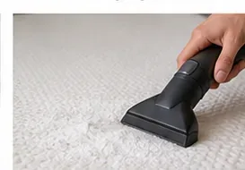 A vacuum upholstery tool removing dry powder from the surface of a memory foam topper