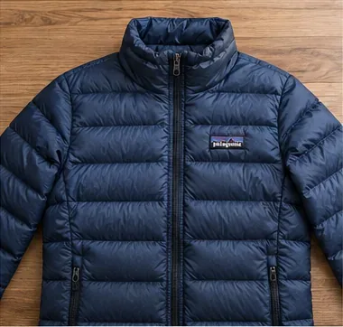 A clean navy down jacket laid flat with evenly filled horizontal baffles after drying.