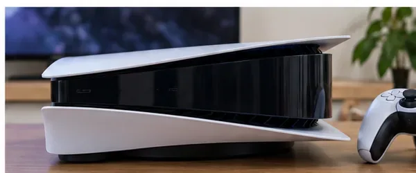 A PS5 console back in a gaming setup beside a controller after external cleaning.