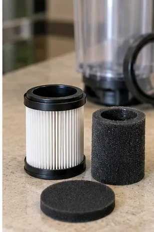 A pleated cylindrical filter and two black foam vacuum filters arranged beside a clear dust bin.