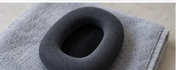 A removed AirPods Max cushion resting flat on a clean dry cloth while it dries