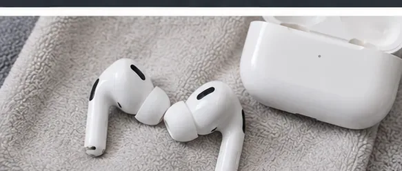 Two AirPods Pro earbuds and an open charging case resting on a dry gray towel
