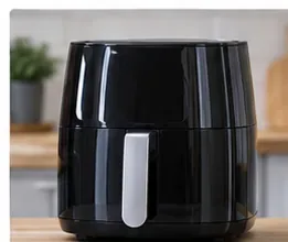 A reassembled black basket-style air fryer standing upright on a kitchen counter after cleaning.