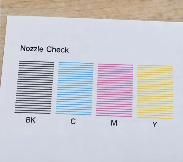A representative nozzle-check sheet with black, cyan, magenta, and yellow line patterns on white paper