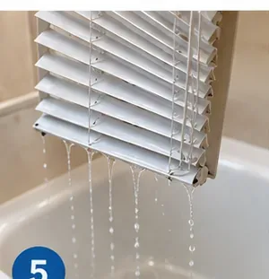 Wet horizontal blinds held at an angle over the bathtub so excess water can drain