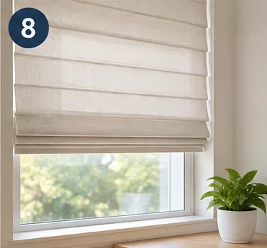 Clean beige fabric blinds hanging evenly above a sunny window with a small plant on the sill