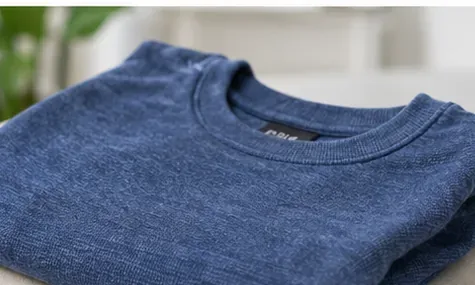 A clean blue shirt laid flat for inspection after washing.