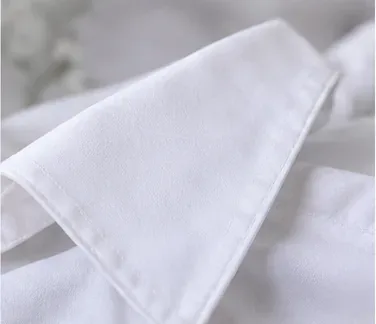 A clean white shirt collar shown close up in bright light after stain treatment.