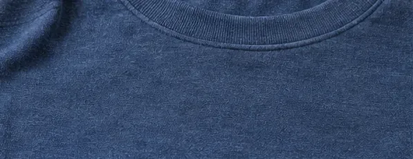 Close view of a blue shirt after washing with the former sticker area looking clean