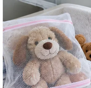 Stuffed animal protected inside a zippered mesh laundry bag