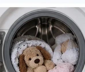 Stuffed animals cushioned by soft towels inside a washing machine drum