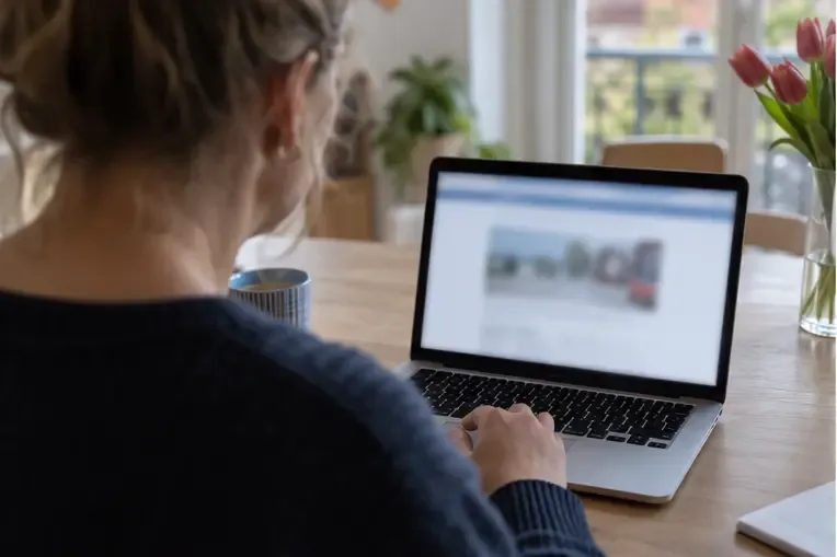 Een inwoner controleert op een laptop de informatie over afvalstromen voordat zij naar de milieustraat gaat