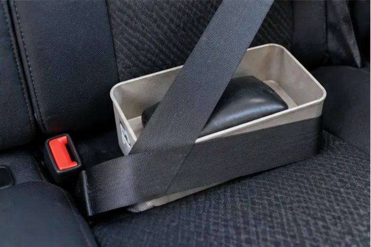 Power bank estufado acomodado em recipiente rígido e imobilizado no banco de um carro durante o transporte
