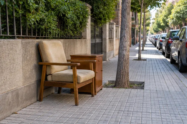 Sillón y mueble auxiliar colocados juntos en una acera amplia sin bloquear el paso peatonal