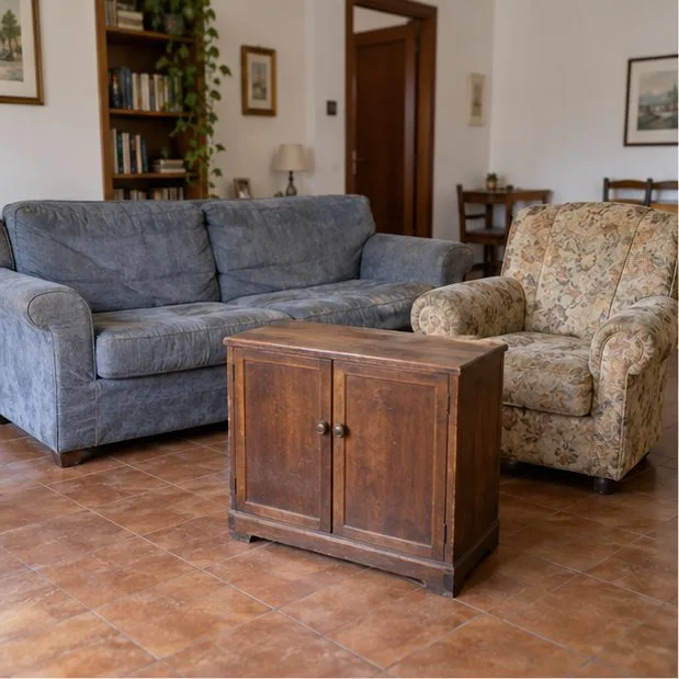 Un divano, una poltrona e un mobile di legno all’interno di un soggiorno.
