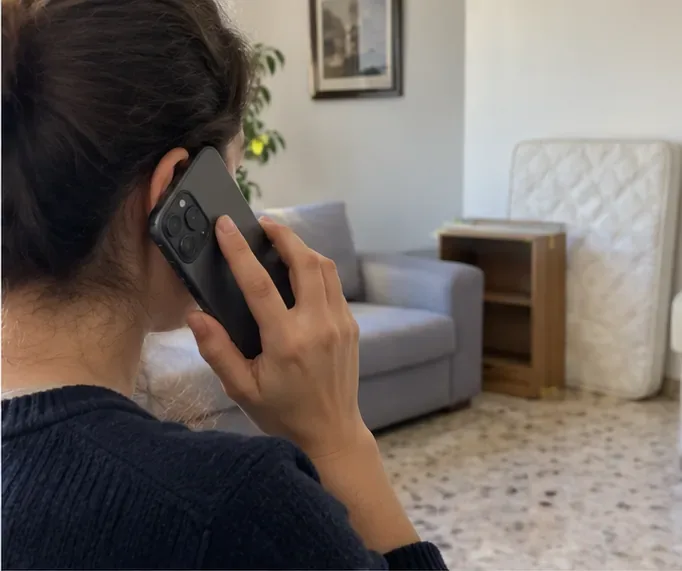 Persona al telefono davanti a materasso e mobile da far ritirare