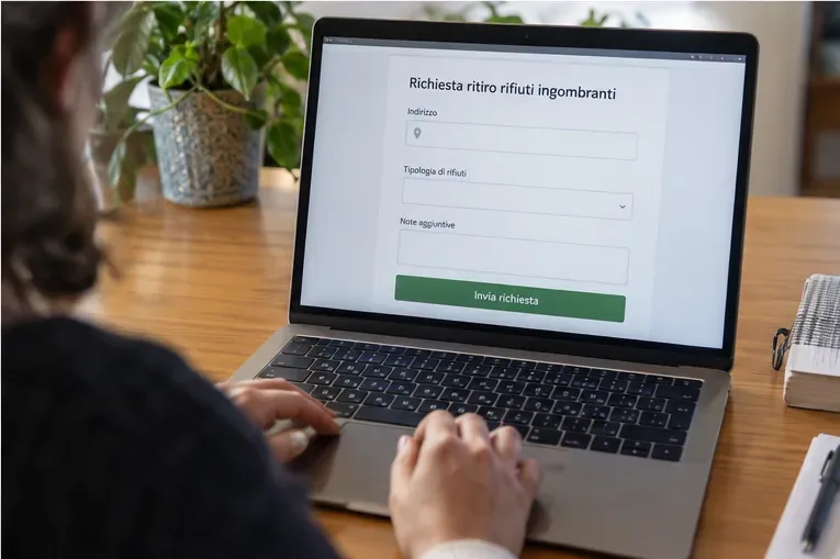 Una persona compila dal computer una richiesta online per il ritiro di rifiuti ingombranti.
