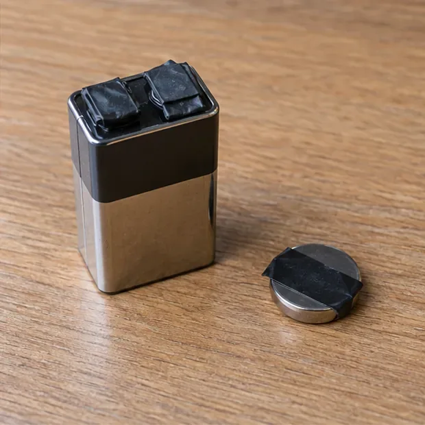 Een 9V-batterij en een knoopcel waarvan de metalen polen met tape zijn afgedekt
