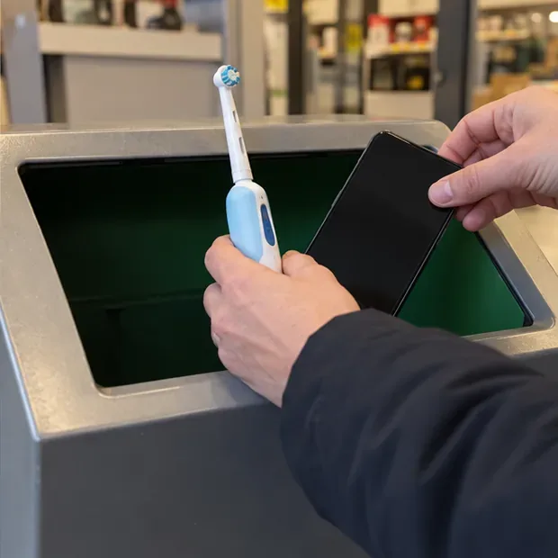 Een elektrische tandenborstel en een smartphone worden als apparaten bij een inzamelopening aangeboden