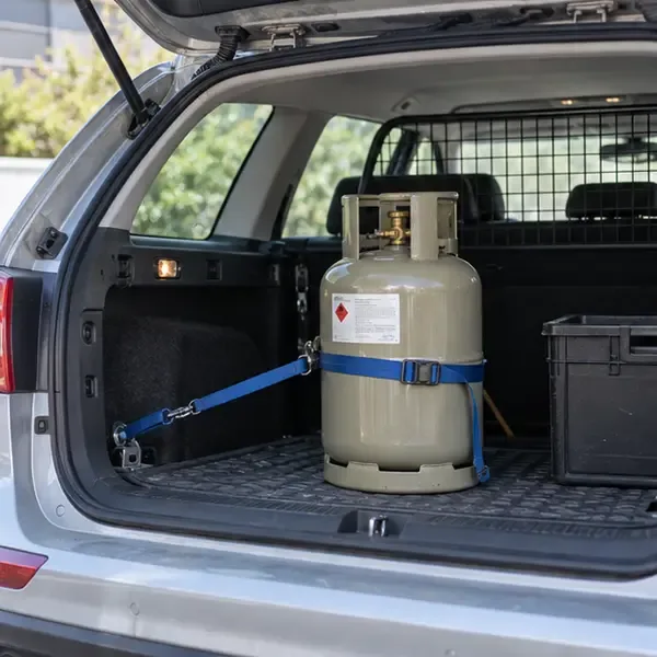 Een gasfles staat rechtop en is met een spanband vastgezet in de laadruimte van een auto.