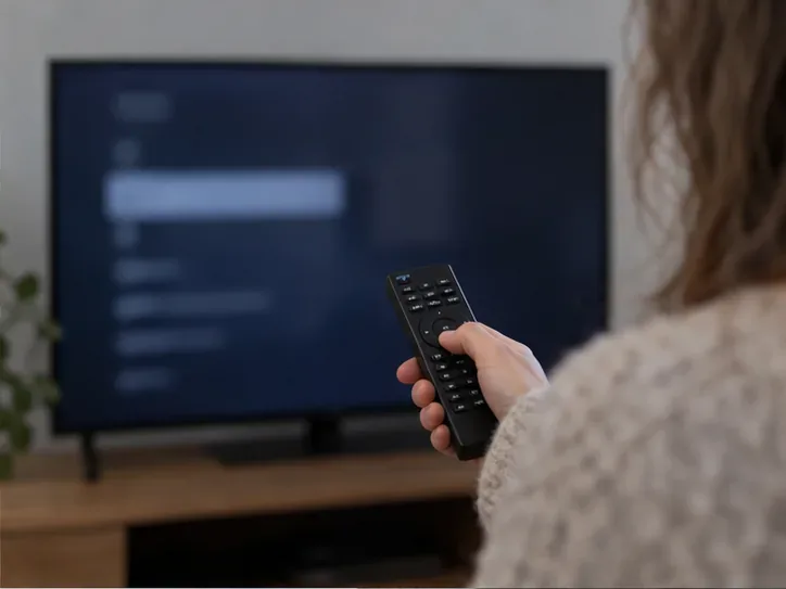 Een afstandsbediening wordt op een televisiescherm met een onscherp instellingenmenu gericht
