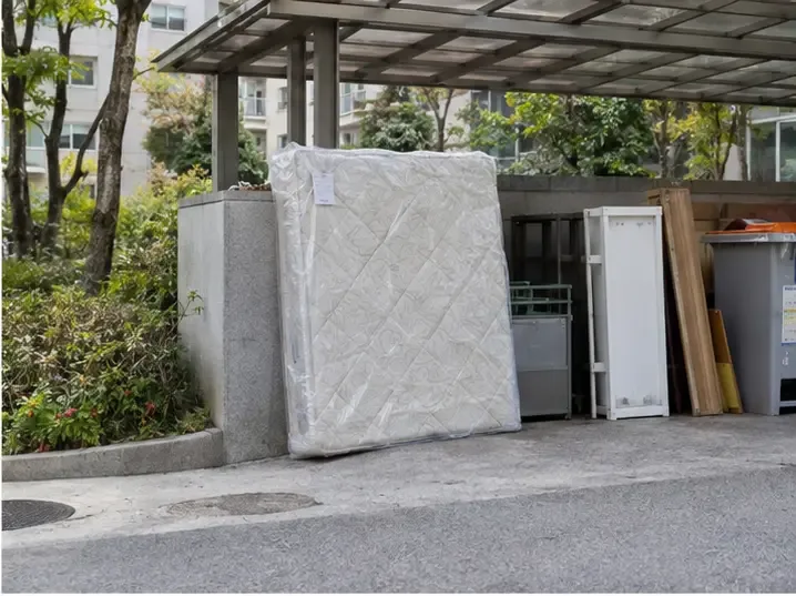 공동주택의 지붕이 있는 지정 배출 공간에 매트리스를 세워 둔 모습