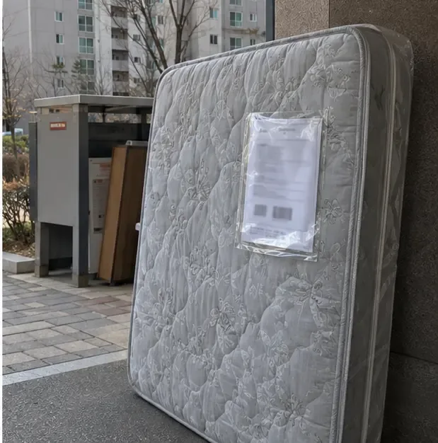 비닐로 보호한 매트리스에 배출 예약표가 부착된 모습