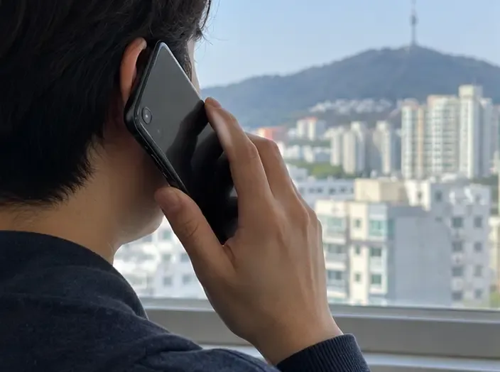 대구 도심을 배경으로 한 사람이 휴대전화로 폐기 안내를 문의하는 모습