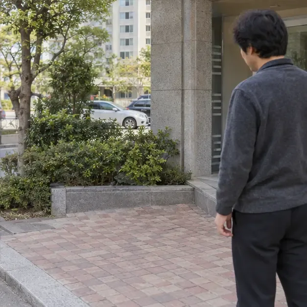 가상 사례에서 주민이 자전거를 배출한 뒤 공동주택 출입구 주변의 지정 장소를 확인하는 모습