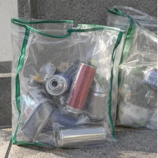 완전히 빈 부탄가스통이 다른 금속 캔과 함께 투명한 재활용 봉투에 담긴 모습