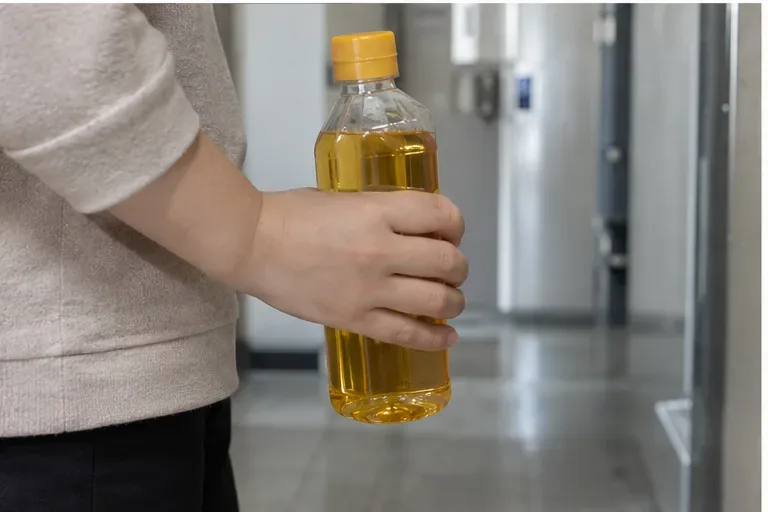 뚜껑이 단단히 닫힌 투명 병에 걸러낸 폐식용유를 보관하는 모습