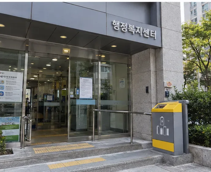 행정복지센터 입구 옆에 전지 모양 표시가 있는 폐건전지 수거함이 설치된 모습