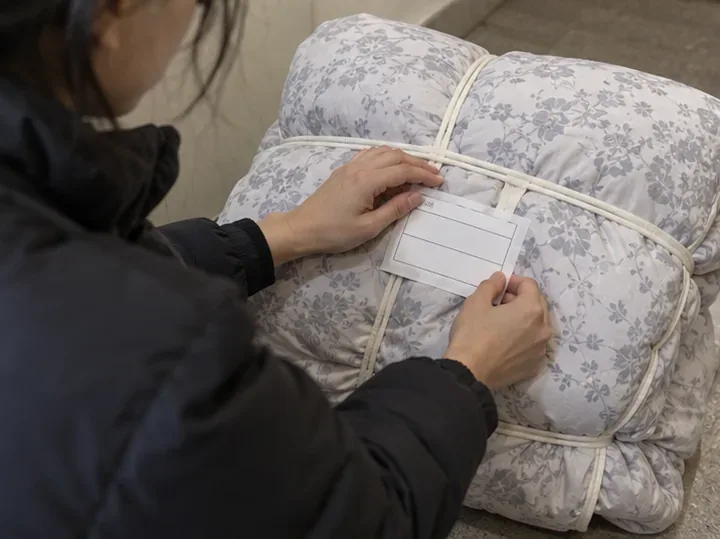 묶은 이불에 배출 확인용 표찰을 부착하는 모습