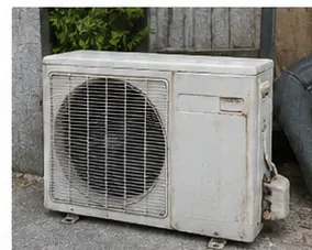 건물 외부에 놓인 오래된 에어컨 실외기를 가까이서 본 모습