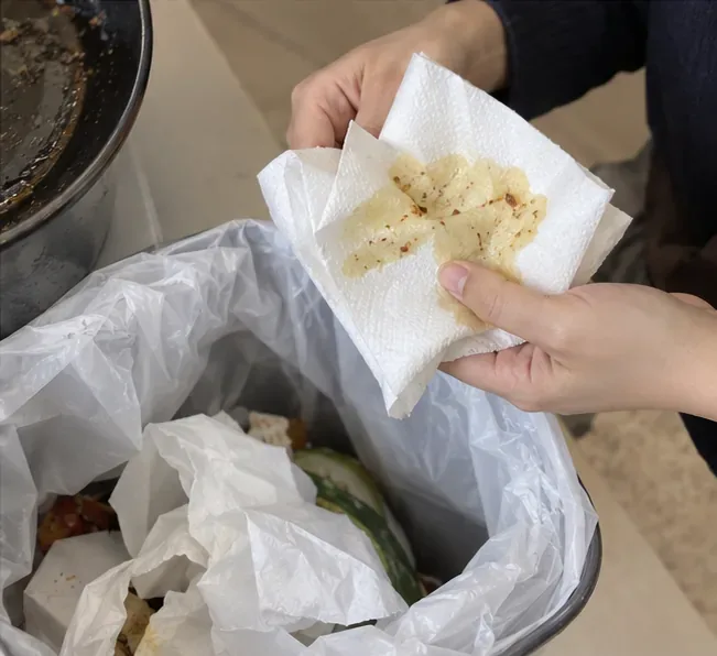 기름이 조금 묻은 키친타월로 팬 안쪽의 남은 기름을 닦고 있다