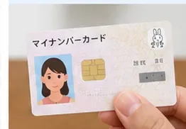 更新手続後にマイナンバーカードを手に持って確認している様子