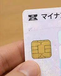 ICチップ付きのマイナンバーカードを手に持って確認している様子