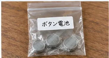 絶縁された複数の丸い電池を、ボタン電池と書かれた透明な小袋へまとめた様子