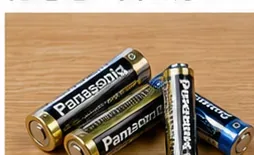 木製の机の上に単3形など複数の使用済み乾電池が並んでいる様子